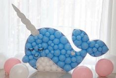 a blue whale made out of balloons on a table