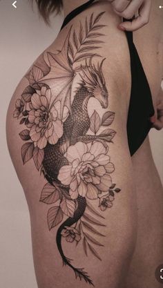 a woman's thigh with flowers and a koi fish tattoo on her side