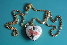 "Vintage handpainted cloisonne enamel heart-shape pendant necklace with multicolor flower motive on white bottom and goldcolor metal chain. Painting made on copper base, pendant alike at both sides and chain closed by lobster clasp. Size:    chain 16 \"/ inch or 40.5 cm long, pendant 1.2 \"/ inch or 3 cm long with loop, 0.9 \"/ inch or 23 mm wide. Exellent vintage condition!" Vintage Enamel Heart Necklaces, Vintage Heart Enamel Necklaces, Vintage Enamel Heart Necklace, Vintage Heart Enamel Necklace, Gold Heart-shaped Enamel Necklace, Heart-shaped Gold Enamel Necklace, Gold Enamel Heart Necklace For Gift, White Hand Painted Heart Jewelry, Hand Painted White Heart Jewelry