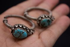 Silver ear ornaments. The hoops are made of pearled wire and the bezel is decorated with Turquoise. Excellent workmanship with a great patina for its age. This particular design is worn in pairs by women from Kham in East Tibet. These pieces might have been handed down to generations. *wear and tear as per age, intact. Weight: 28 grams Ring Size: 34mm Origin: Early 20th c Tibet Traditional Turquoise Metal Jewelry, Handmade Ceremonial Toe Ring Jewelry, Handmade Ceremonial Toe Ring, Traditional Hand Forged Jewelry As Gift, Traditional Hand Forged Jewelry For Gifts, Traditional Handmade Toe Ring Jewelry, Traditional Hand Forged Jewelry Gift, Traditional Hand Forged Jewelry For Wedding, Traditional Hand Forged Wedding Jewelry