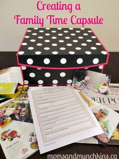 a black and white polka dot box sitting on top of a table next to magazines