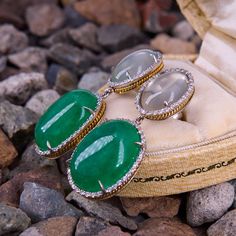 These dazzling two-section dangle earrings each feature one (1) prong set oval cabochon cut natural dyed green quartz cabochon that is bordered with thirty-six (36) prong set round brilliant cut diamonds. Atop each earring is one (1) prong set oval cabochon cut natural moonstone that is bordered with thirty (30) prong set round brilliant cut diamonds. The earrings measure 42.0mm X 17.4mm and are finished with friction backs. Luxury Green Oval Earrings, Elegant Green Gemstone Cabochons, Luxury Oval Cabochon Gemstone Earrings, Green Gemstone Cabochons Fine Jewelry, Fine Jewelry Green Cabochon Earrings, Luxury Oval Gemstone Earrings, Elegant Oval Cabochon Jade Jewelry, Luxury Oval Cabochon Earrings For Anniversary, Fine Jewelry Oval Cabochon Earrings