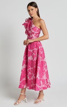 a woman wearing a pink dress with flowers on it