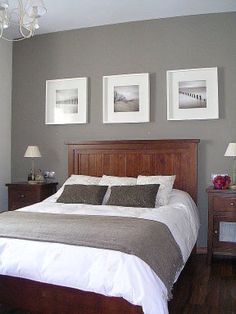 a large bed sitting in a bedroom next to two pictures on the wall above it