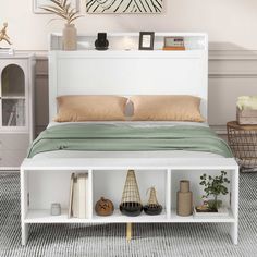 a white bed sitting in a bedroom on top of a carpeted floor next to a book shelf