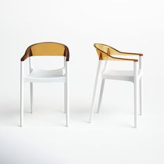 two white and brown chairs sitting next to each other on a white surface with one chair facing the other