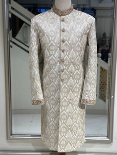 Our Light Golden Sherwani for men is a tribute to classic style and fine workmanship; drape yourself in regal splendor. The rich silk fabric underneath is accentuated by the exquisite hand-stitched zardozi embellishments on the collar and cuffs of this lavish garment. A touch of tradition is added to the modern design by the golden hue of the elaborate tilla work embroidered onto the silk, making this ensemble truly one-of-a-kind. Since 1974, we have been committed to delivering premium quality, Men Pakistani Wedding, Golden Sherwani, Indian Wedding Sherwani, Wedding Sherwani For Men, Traditional Light, Sherwani For Men, Wedding Sherwani, Nehru Jacket, Nehru Jackets