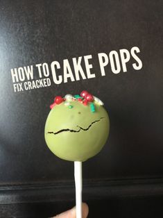 a hand holding a green cake pops with sprinkles