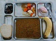 a lunch tray with beans, carrots, bread and other food items on it