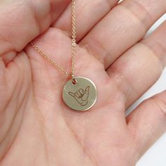 "Hand stamped hang loose symbol on round charm (13mm) Sterling silver cable chain. PLEASE NOTE: All personalized items are handstamped by me, and may not be perfectly straight, making them each one of a kind and unique. Personalized items are final sale. No exceptions. Shaka sign. The \"shaka\" sign is a common greeting in the Hawaiian culture, subsequently also used in surfer culture. The shaka sign, sometimes known as \"hang loose\", is a gesture of friendly intent often associated with Hawaii Small Personalized Charm Necklaces For Everyday, Personalized Small Charm Necklaces For Everyday, Everyday Etched Round Pendant Necklaces, Everyday Etched Round Pendant Necklace, Nickel Free Round Pendant Necklaces For Friendship, Nickel-free Round Pendant Necklaces For Friendship, Nickel-free Round Pendant Necklace For Friendship, Minimalist Round Hand Stamped Charm Necklaces, Engraved Sterling Silver Charm Necklaces For Friendship