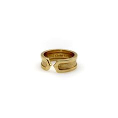 This is part of Chairish's Fine Jewelry Collection.  This 18k gold ring is a play on the classic double-c Cartier design. An abstracted c raises up as an exterior border that continues around the band. Two c’s back up against each other, meeting at a sharp point in the middle of the ring for a clean, modern look.  The outside border has a high polish, while the interior layer has a brushed gold finish. The design is subtle and simplistic, and the ring makes for an excellent staple in any jewelry Timeless Polished Cartier Rings, Luxury Promise Bands, Luxury 14k Gold Signet Ring With Open Band, Timeless Cartier Rings For Formal Occasions, Timeless Cartier Formal Rings, Modern Cartier Rings With Polished Finish, Timeless Cartier Rings With Round Band, Cartier Classic Ring With Polished Finish, Timeless Cartier Ring With Round Band