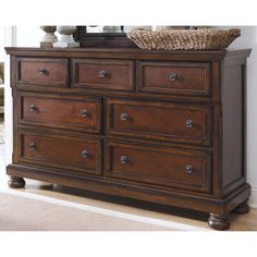 a brown dresser with drawers and a mirror