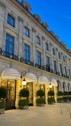 the entrance to a large building with many windows and lights on it's sides