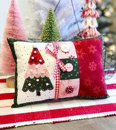 two decorative christmas trees on red and white pillows