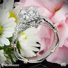 a diamond ring sitting on top of a bouquet of flowers