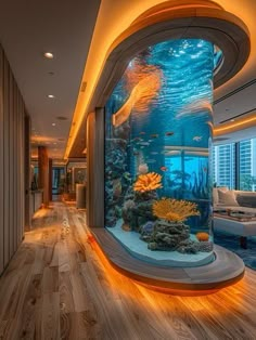 a fish tank in the middle of a room with wood flooring and large windows