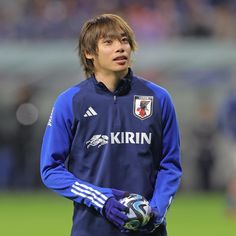 a young man holding a soccer ball on top of a field