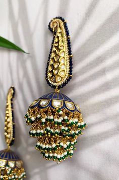 Blue enamel meenakari handpainted chandbaali featuring glass kundan work, cubic zirconia studs, pearl embellishments and plated with 22kt gold. These pretty earrings are a perfect match to all things pastels. The earring features pretty floral motif in glass kundan work and delicate cubic zirconia. The chandbali are embellished with high grade shell pearls. These earrings are handpainted by artisans of Kashmir who are famous for papier-mache artwork. Detailed hand painting alongside studded kund Fusion Peacock Jhumkas For Diwali, Fusion Style Peacock Jhumkas For Diwali, Festive Fusion Jhumkas With Peacock Design, Diwali Fusion Style Jhumkas With Peacock Design, Blue Temple Jewelry Danglers With Latkans, Blue Temple Jewelry Danglers For Festive Occasions, Multicolor Kundan Jhumkas With Peacock Design, Blue Kundan Temple Jewelry Earrings, Fusion Kundan Jhumkas With Meenakari