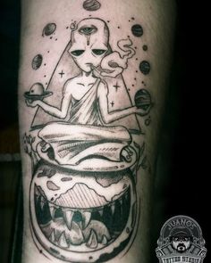 a man's leg with a tattoo on it that has an alien in the bowl