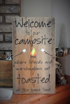 a wooden sign that says welcome to our campsite where friends and marshmallows get toasted at the same time