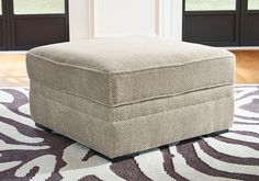 a footstool sitting on top of a rug in front of a door way