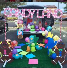 an outdoor candy cart decorated with balloons and paper cut outs for kids'birthdays