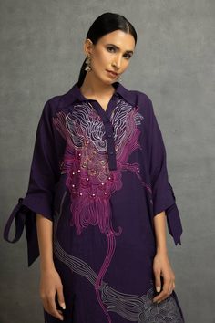 Purple shirt tunic with abstract floral digital print, highlighted with sequin, bead and thread embroidery and knot sleeves. Paired with a pant. - Aza Fashions Elegant Festive Blouse With Printed Motifs, Spring Straight Kurta Blouse With Printed Motifs, Elegant Printed Blouse Piece For Navratri, Elegant Blouse Piece With Printed Motifs For Navratri, Silk Tunic With Resham Embroidery For Designer Wear, Elegant Blouse With Printed Motifs For Designer Wear, Designer Tops With Printed Motifs, Designer Wear Blouse With Printed Motifs, Fusion Style Blouse Piece For Diwali