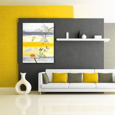 a modern living room with yellow and gray accents, white furniture and large painting on the wall