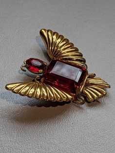 "1940s Sterling Silver Red Rhinestone Bug Butterfly Fur Clip HALLMARKS Sterling on clip mechanism. MEASUREMENTS 2 1/2\" x 2 5/16\" WEIGHT 24.26 Grams.               MATERIALS Sterling Silver, Glass and Gold Vermeil. CONDITION In very good to excellent condition, please use all pictures as part of item's description. Spectacular 1940s era Sterling Silver fur clip featuring a bug or butterfly design. Clip has large Emerald cut red glass stone and smaller oval cut stone as the head.  The stone that Vintage Ruby Evening Jewelry, Antique Red Brooch For Formal Occasions, Vintage Red Brooches For Formal Occasions, Vintage Red Jewelry For Evening, Jewelry Holders, Jewelry Boards, A Bug, Silver Glass, Vermeil Jewelry