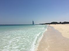 the beach is clean and clear with people walking on it