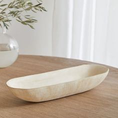 a white bowl sitting on top of a wooden table