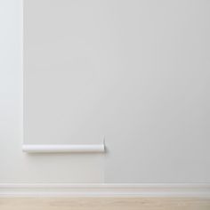 an empty room with white walls and wood flooring