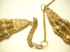 "Vintage 1960s gold tone metal, triple strand necklace. 20\" necklace with 13\", 15\", and 17\" strands. Gold tone beads and spacers. Gold tone swirly discs dangle from the 17\" lower strand. This is a funky Cleopatra style necklace. Nearly perfect condition--nothing broken. Unsigned." Vintage Necklace With Dangling Beads For Festive Occasions, Multi-strand Gold Jewelry For Celebration, Vintage Double Strand Metal Necklace, Gold Multi-strand Jewelry For Festivals, Festive Multi-strand Gold Jewelry, Vintage Dangling Beads Necklaces For Festivals, Vintage Necklaces With Dangling Beads For Festivals, Vintage Jewelry With Dangling Beads For Festive Occasions, Vintage Yellow Gold Beaded Necklace