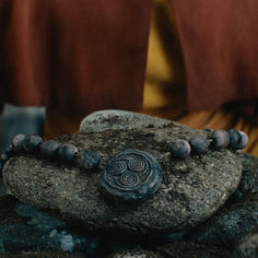 a close up of a stone with beads on it and a person in the background