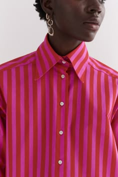 Contrasting Pink and red stripe oversized tailored shirt is made of 100% cotton. The shirt features an oversized collar, button stand with mother of pearl buttons and oversized cuffs with our signature button detail. Contrasting stripe on the cuff, collar and back yoke. Pink Button Up, Striped T Shirt Outfit, Red Shirt Women, Red And Pink Outfit, Pink And Red Outfit, Pink And Red Stripes, Pink Shirt Outfit, Pink Wide Leg Trousers, Pink Striped Shirt