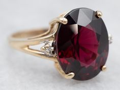 "Absolutely gorgeous! This sleek yellow gold mounting required a good-sized stone to set complete, and we chose a truly high-quality garnet! The ring is really all about the center stone, and the simple styling and two accent diamonds create the perfect stage. The center stone is a gorgeous, very fine quality garnet, which is a beautiful crimson color with undertones of fire burgundy. Metal: 10K Yellow Gold Gem: Garnet 7.95 Carats Gem Measurements: 10.6 x 13.5 mm, Oval Accents: 2 Diamonds totaling .01 Carats, H in Color, SI in Clarity Ring Size: 6.50 Marks: \"10KA/(C)\" Stamped on the inside band To view a video of this piece check out the link below: https://vimeo.com/825625984 SKU #: A24967 Each piece has been identified and graded by a Graduate Gemologist who has been certified by the G Crimson Color, Garnet Ring Vintage, Garnet And Diamond Ring, Ring Three Stone, Second Choice, Gold Statement Ring, Three Stone Ring, Etsy Gold Ring, January Birthstone