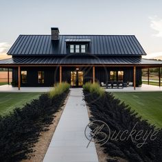 a house with a black metal roof and white walkway leading up to the front door