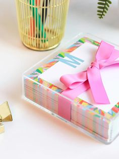 a box with a pink bow on it next to a gold cup and other items