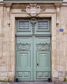 an old building with two large green doors