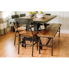 a dining room table with four chairs and a bowl of fruit on top of it