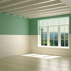 an empty room with green walls and white trim on the windowsills is shown