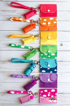 the rainbow dog leashes are lined up on a white wooden surface with different colors