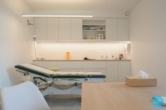 a hospital room with an exam table and medical equipment on the counter top in front of it