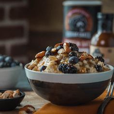 a bowl filled with fruit and nuts on top of a table next to a bottle of booze