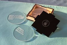 two clear glass coasters sitting on top of a blue cloth covered tablecloth next to each other