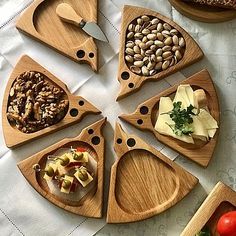 several wooden trays with different types of food in them on a white table cloth