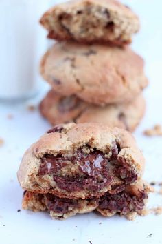 chocolate chip cookies stacked on top of each other next to a glass of milk