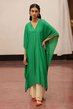 Emerald asymmetric kaftan, accentuated with sequins embroidered edges. Paired with a pant.
Components: 2
Pattern: Placement Embroidery
Type Of Work: Sequins
Neckline: V Neck
Sleeve Type: Three Quarter Sleeves
Fabric: Munga Silk: Kafta and Organza Silk: Pant
Color: Green
Other Details: 
Model height: 5ft 7inches, wearing size S
Length: 47 inches
Occasion: Puja - Aza Fashions Placement Embroidery, Coord Sets, Silk Pant, Silk Kaftan, Green Sequins, Silk Pants, Three Quarter Sleeves, Quarter Sleeve, Aza Fashion