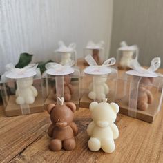 several small teddy bears in clear boxes on a table