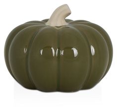 a green ceramic pumpkin sitting on top of a white table